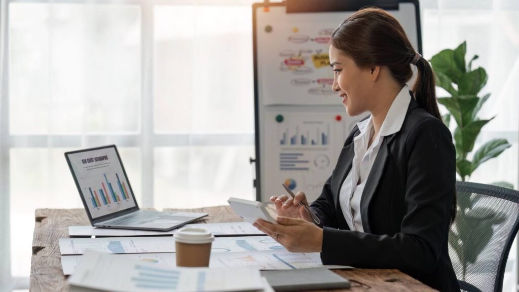 A person sits at a desk and works on her laptop on a section 125 plan.
